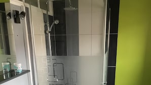 A modern bathroom with a white sink, a glass shower enclosure, and a green accent wall. - Leffrinckoucke Plage (Leffrinckoucke)