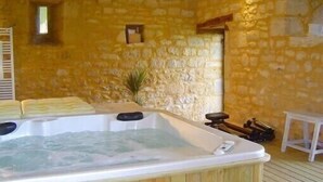 A stone-walled room with a wooden hot tub and a small table. - magnificient 16th century MANOR HOUSE with POOL and JACUZZI (Cénac-Et-Saint-Julien)