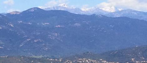 A coastal town with a mountain range in the background.