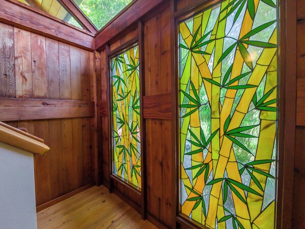 A wooden interior with two stained glass windows featuring bamboo patterns.