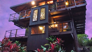 Un immeuble à plusieurs étages, doté de balcons et de grandes fenêtres, entouré de verdure.