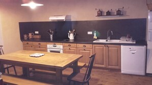 Una cocina con armarios de madera, estufa, lavamanos y refrigerador.