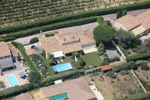 Vue aérienne d’un quartier résidentiel avec de nombreuses maisons, une piscine et des jardins bien entretenus.