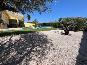 A residential property with a swimming pool, a patio area, and a well-maintained garden.