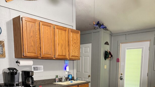 A kitchen with wooden cabinets, a coffee maker, and a sink. - Cozy 2BR Retreat Near Hurley-Ironwood – Trails, Skiing, Snomobiling (Montreal)