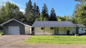 A two-story building with a garage, a covered porch, and a small front yard. - Cozy 2BR Retreat Near Hurley-Ironwood – Trails, Skiing, Snomobiling (Montreal)