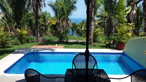 A swimming pool with a view of the ocean, surrounded by tropical vegetation. - Secluded 2 bedroom duplex with private pool and gorgeous jungle and ocean views! (El Divisadero)