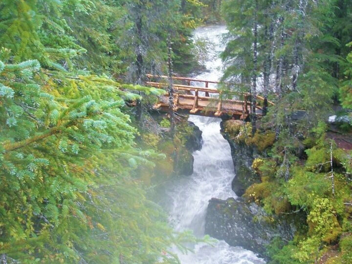 A waterfall with a wooden bridge.