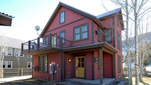 A two-story red building with a balcony, a front door, and a satellite dish. - Red Poppy- Beautiful home 3 blocks from Elk Ave (Crested Butte)