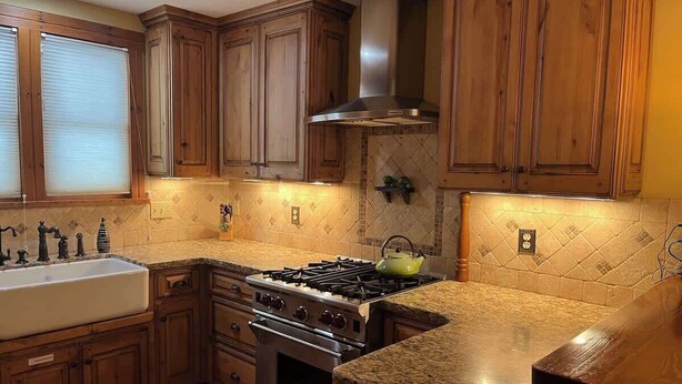 A kitchen with wooden cabinets, a stove, and a sink. - Red Poppy- Beautiful home 3 blocks from Elk Ave (Crested Butte)