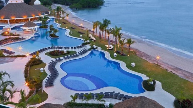 Un complexe hôtelier doté d’une grande piscine, d’espaces de détente au bord de la plage et offrant une vue sur l’océan.