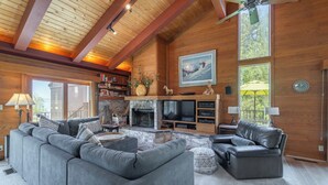 A spacious living room with a fireplace, large sofas, and a television.