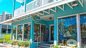 A turquoise building with a sign reading "Gidget's Surf Shop" and a visible phone number. - Prime Beachfront with Views Views Views! (Siesta Key)