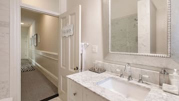 A bathroom with a marble sink, a large mirror, and a sign that reads 'LE BAIN'.