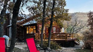 Un chalet rustique doté d’une terrasse en bois et d’un porche abrité.