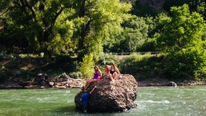 Un paysage naturel comprenant une rivière, une formation rocheuse et des arbres.