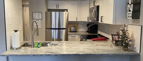 Fridge, microwave, coffee/tea maker, cookware/dishes/utensils