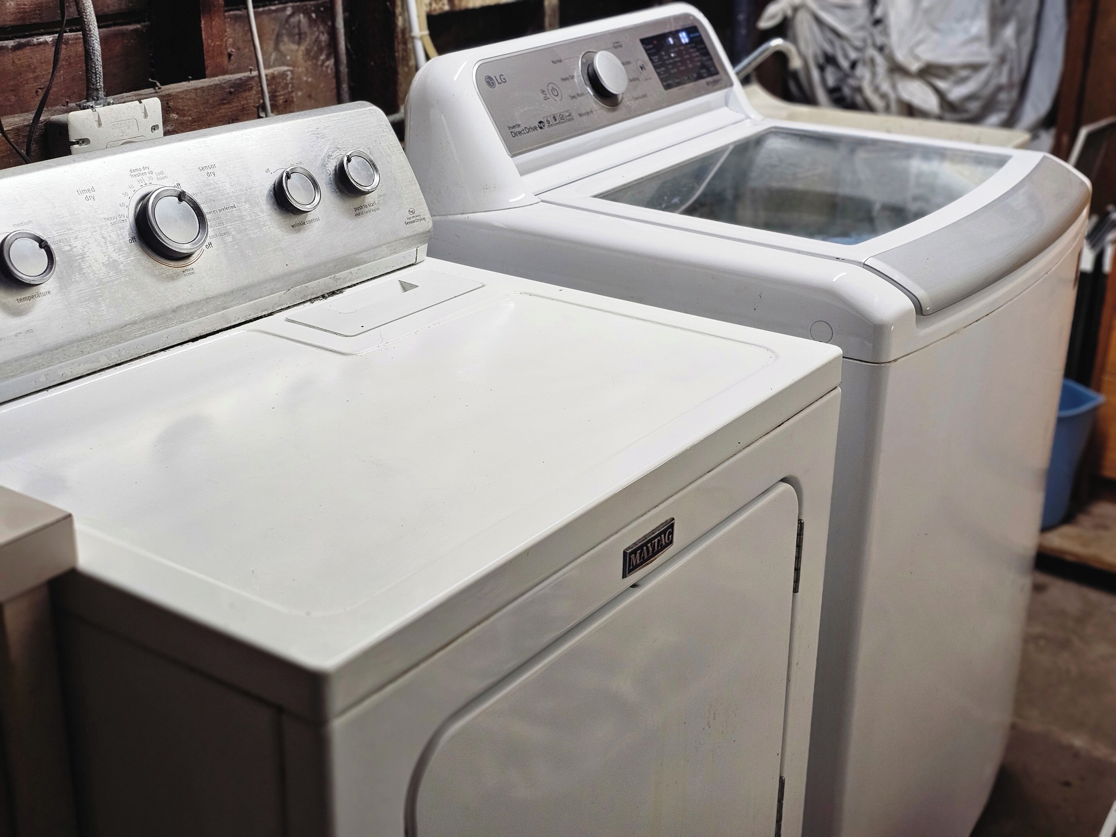 A front view of a white washing machine with a control panel and a dryer.