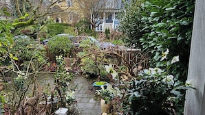 Ein Garten mit verschiedenen Pflanzen und einem kleinen Teich.