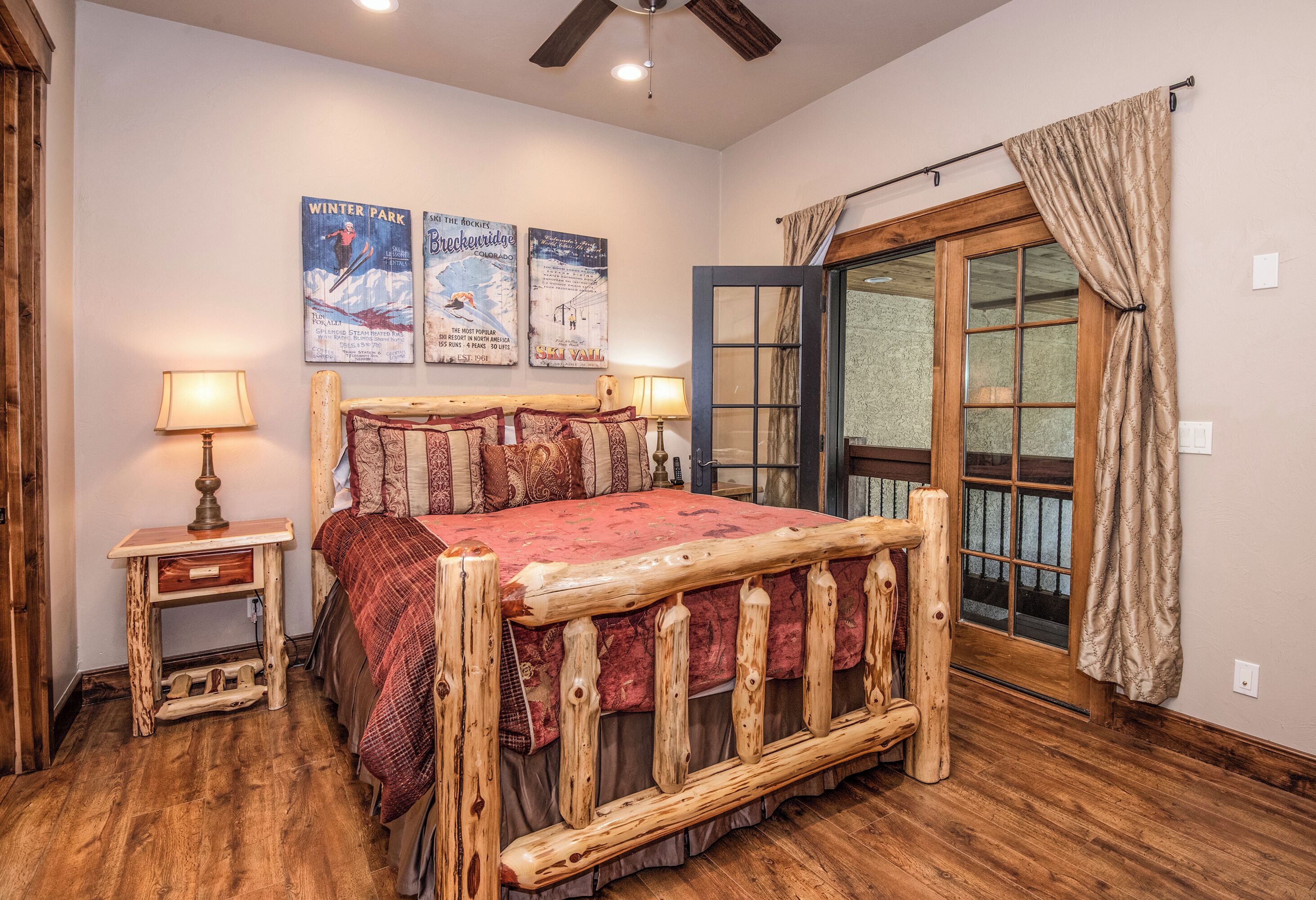 A rustic bedroom with a wooden bed frame, a nightstand with a lamp, and a window with curtains.