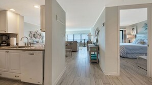 A modern kitchen with white cabinets, a dishwasher, and a countertop with a coffee maker. - Beautiful Oceanfront Condo With Breathtaking Beach Views , 3RD floor, C117 (Fernandina Beach)