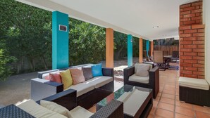 Un espace extérieur aménagé en terrasse, avec des meubles en osier et un mur en briques.