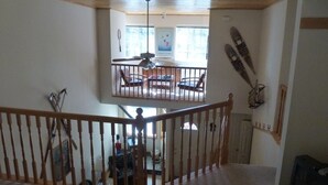 Une pièce spacieuse avec un plafond haut et un balcon.