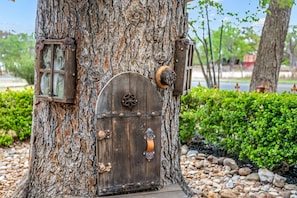 Un árbol con una puerta de madera y una ventana pequeña.