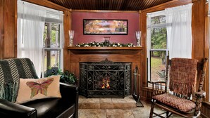 Una habitación acogedora con chimenea, paredes de madera y una zona de estar confortable.