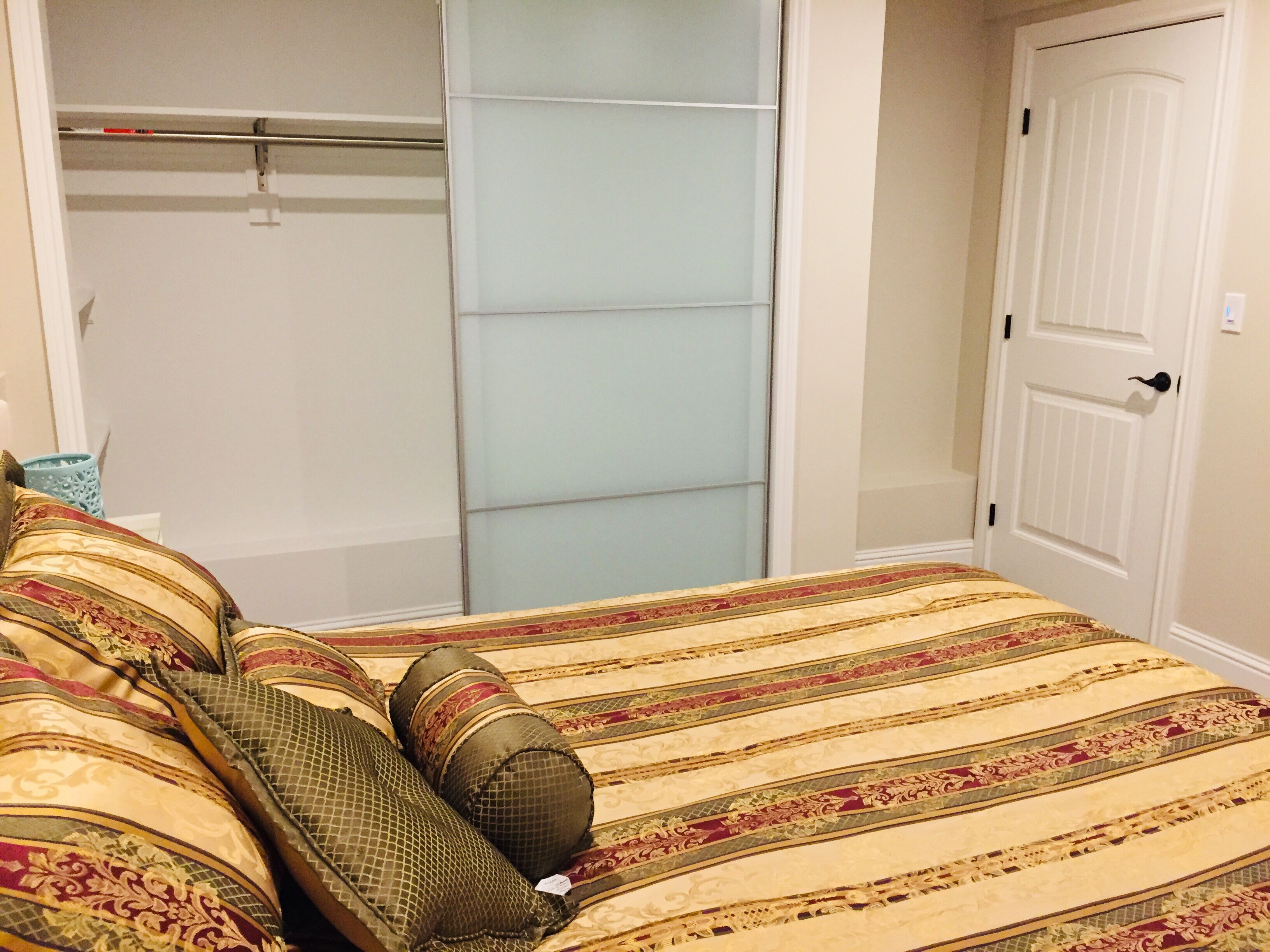 Un dormitorio con cama, armario y puerta.