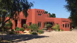 A building with a red facade, a paved courtyard, and a fountain.