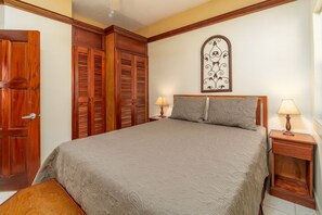 Una camera da letto con un letto, due comodini, un'armadio in legno e un elemento decorativo a parete.