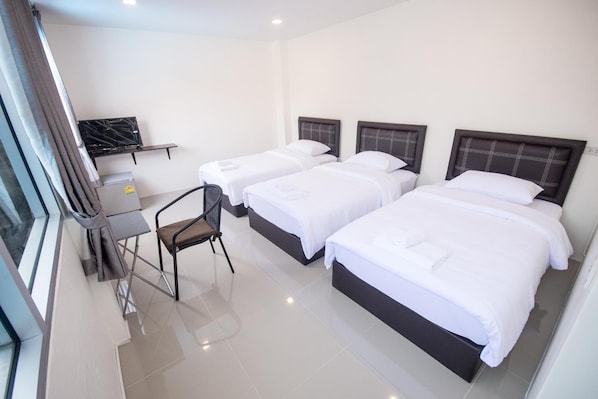 Habitación de hotel con dos camas, un escritorio y una silla.