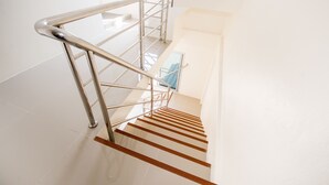 A modern staircase with metal railings and wooden steps. - Nina Guesthouse (Bangkok)