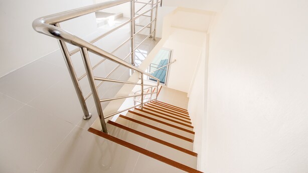 A modern staircase with metal railings and wooden steps. - Nina Guesthouse (Bangkok)