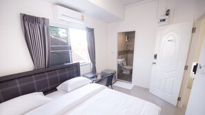 A hotel room with a large bed, a desk, a shower area, and a door marked with the number 302. - Nina Guesthouse (Bangkok)