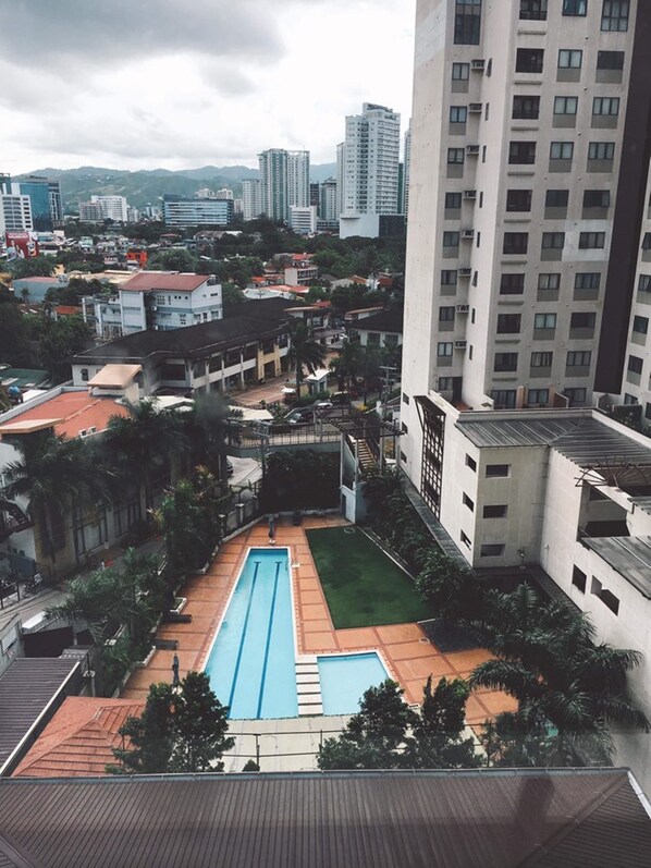 Zona residencial con piscina, rodeada de edificios y vegetación.