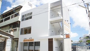 A modern two-story building with a ground-floor cafe and upper residential units. - Trip Spot 774 (Naha)