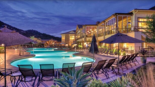 A hotel with a swimming pool, lounge chairs, and a mountain backdrop. - Welk Resort Villas - Winter Wonderland Weekend (Escondido)