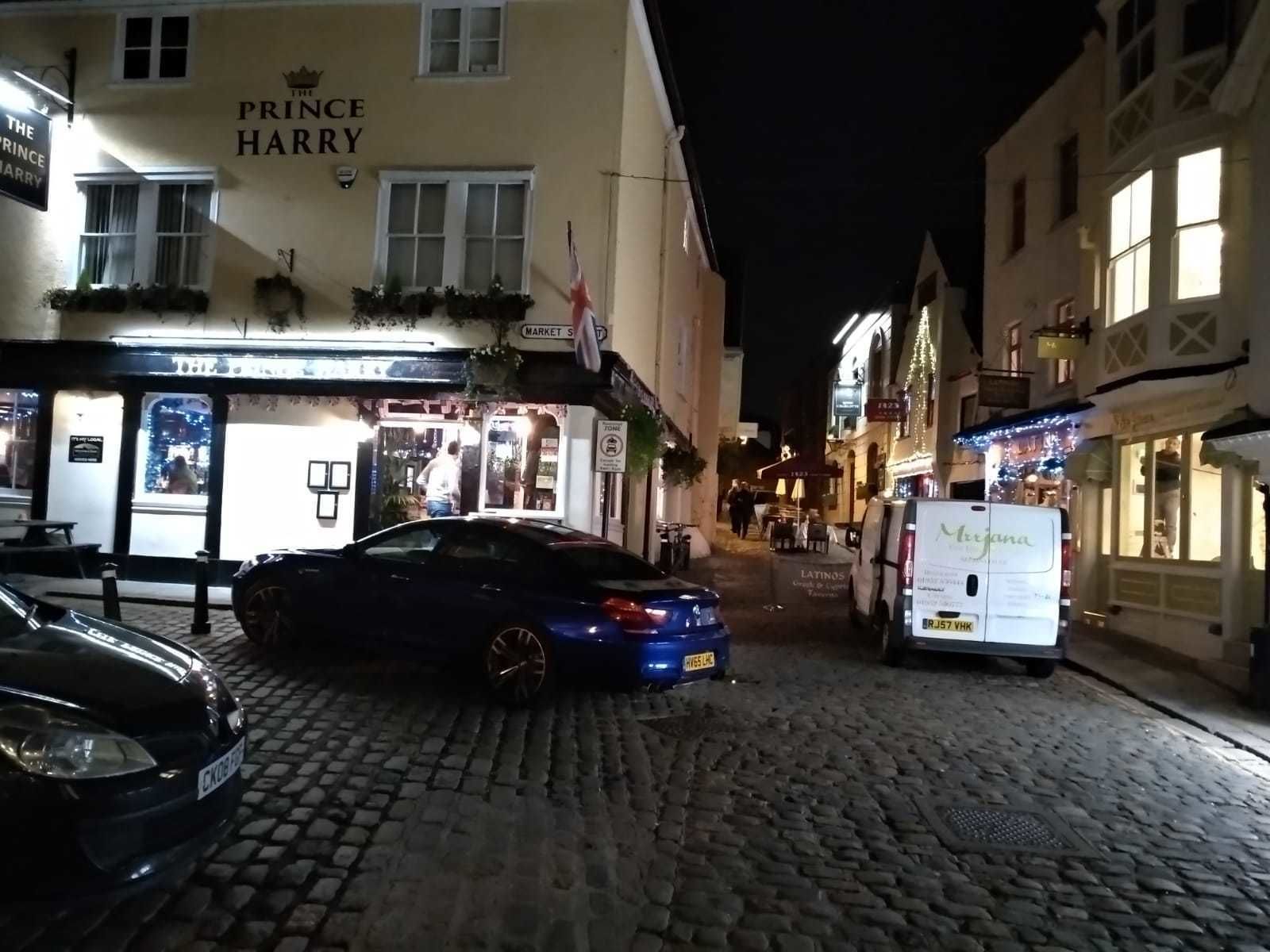 A cobblestone street with a building labeled "The Prince Harry" on the left.