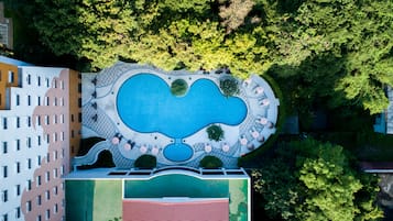 Una piscina al aire libre, sombrillas, sillones reclinables de piscina