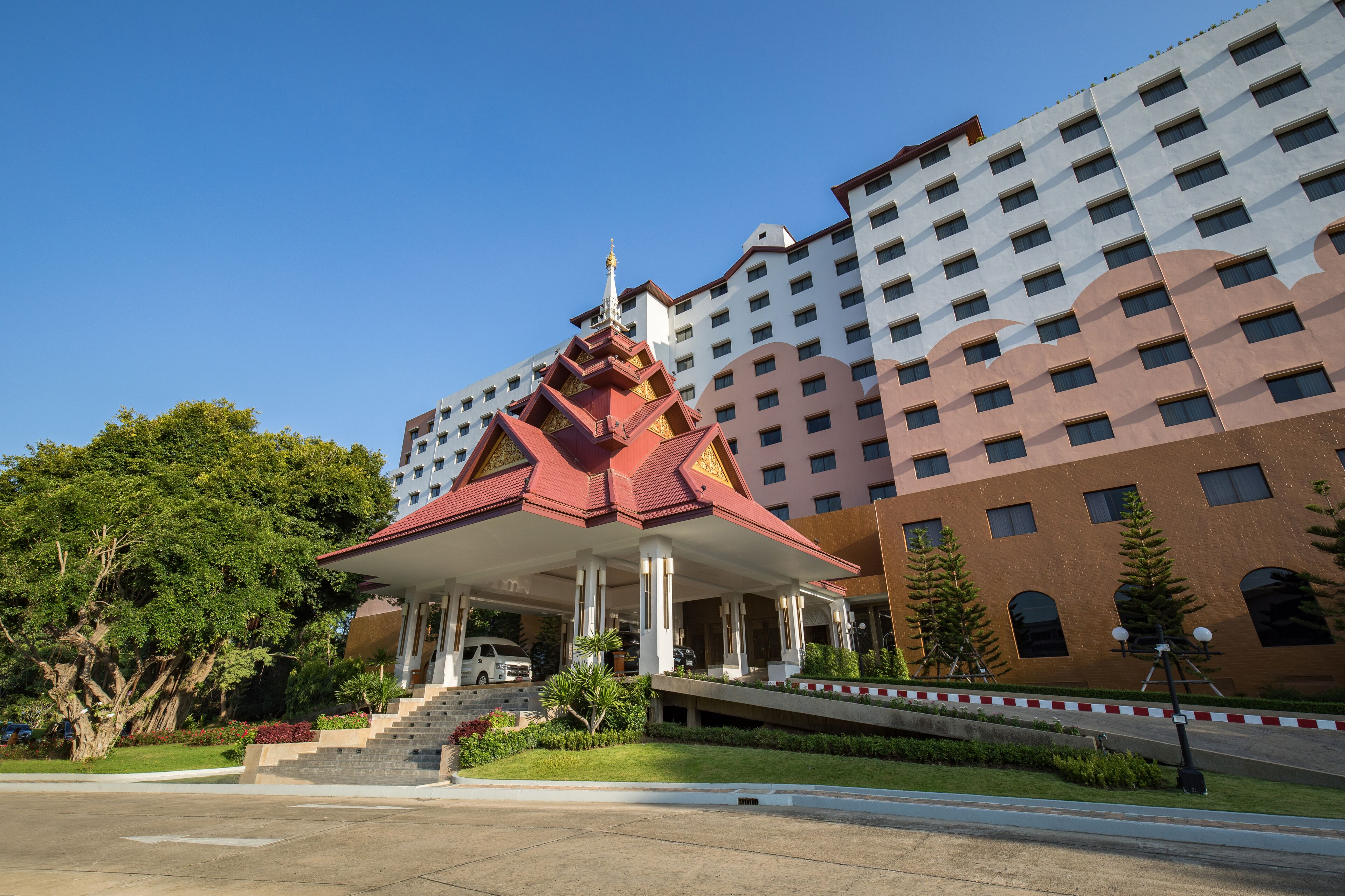 A multi-story hotel with a traditional Thai architectural pavilion in front.