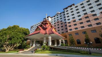 A multi-story hotel with a traditional Thai architectural pavilion in front.