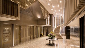 A spacious lobby with a marble floor, a central round table with a floral arrangement, and a grand staircase. - The Heritage Chiang Rai Hotel and Convention (Chiang Rai)