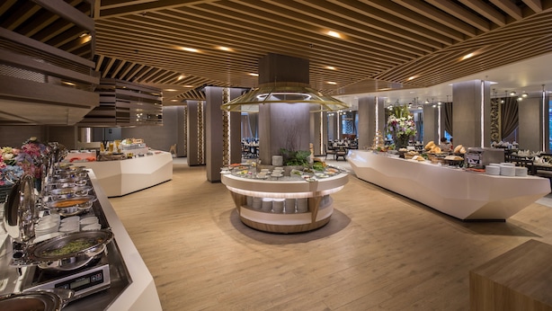 A buffet setup with multiple serving stations, a central decorative column, and a modern ceiling design. - The Heritage Chiang Rai Hotel and Convention (Chiang Rai)