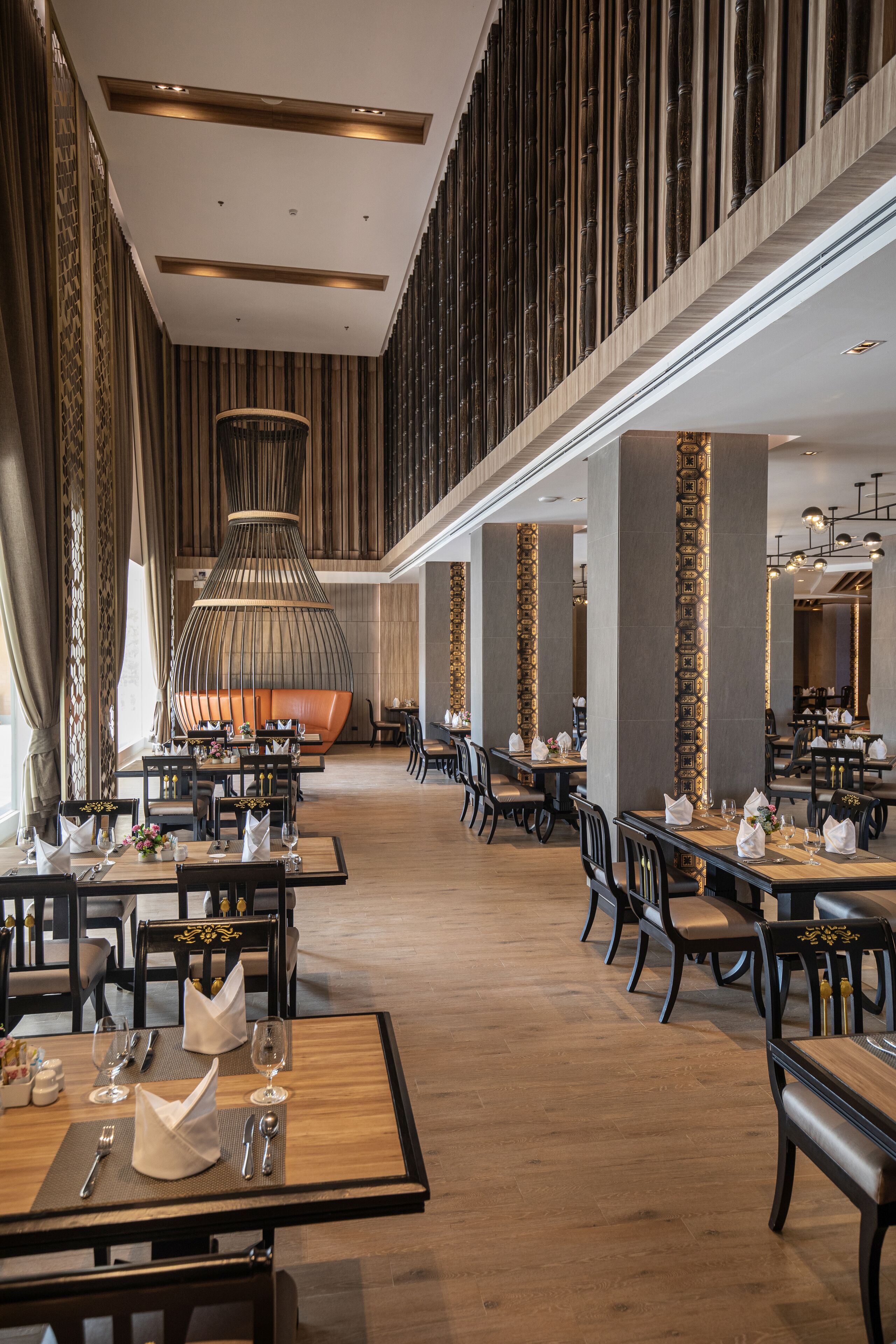 A spacious restaurant with high ceilings, modern lighting, and a central seating area.