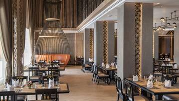 A spacious restaurant with high ceilings, modern lighting, and a central seating area.