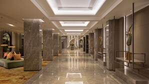 A spacious, well-lit hallway with marble flooring, a central staircase, and modern decor including a dragon sculpture. - The Heritage Chiang Rai Hotel and Convention (Chiang Rai)