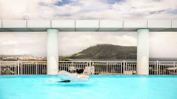 Una piscina con vistas despejadas a un paisaje montañoso y una masa de agua al fondo.