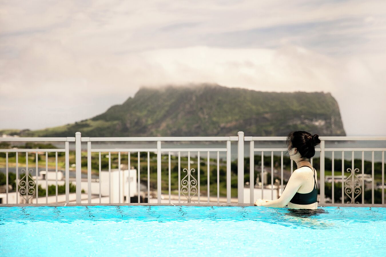 Una persona en una piscina con vistas a un paisaje montañoso.